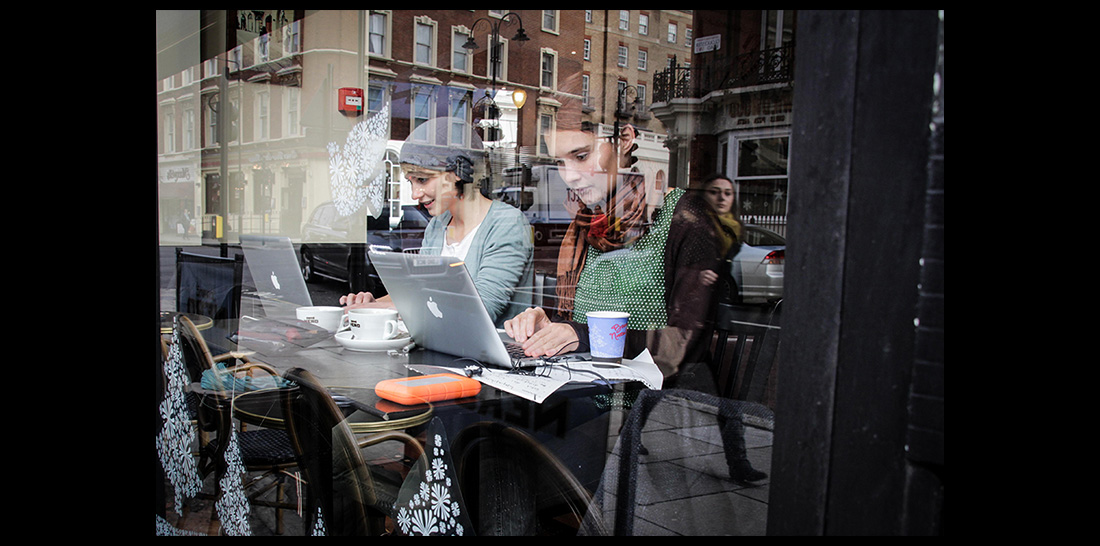 Amrai und Caterina in einem Londoner Café bei der digitalen Arbeit